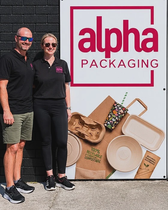 Matt and Eryn, the owners of Alpha Packaging, beside the sign at the Nerang warehouse